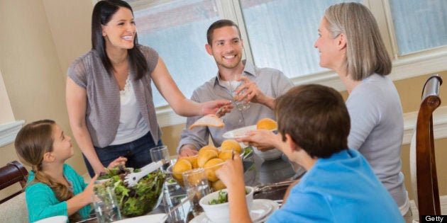 Modern mother serving dinner to her three generation family