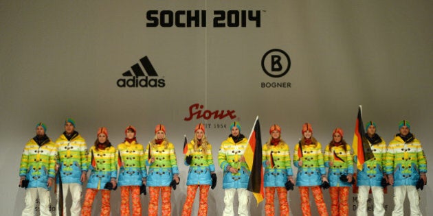 Models and German athletes hold the German flag as they present the official German olympic team's outfit for the next Olympic wintergames in Sotchi, during a fashion show at the Duesseldorf fair ground, western Germany, on October 1, 2013. AFP PHOTO / PATRIK STOLLARZ (Photo credit should read PATRIK STOLLARZ/AFP/Getty Images)