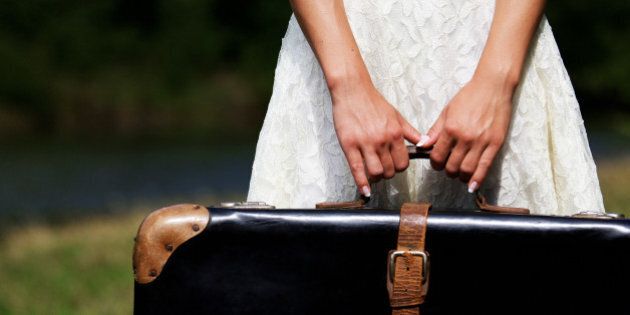 hands of a young woman with a suitcase