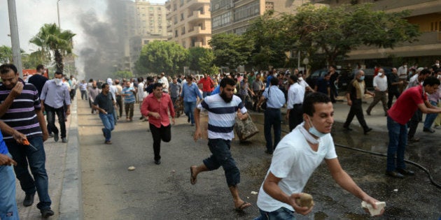 Egyptian Muslim Brotherhood supporters run from police in a street leading to Rabaa al-Adawiya protest camp in Cairo on August 14, 2013. Egypt's Muslim Brotherhood said at least 250 people were killed and over 5,000 injured in a police crackdown on two major protest camps held by supporters of ousted president Mohamed Morsi. AFP PHOTO / KHALED DESOUKI (Photo credit should read KHALED DESOUKI/AFP/Getty Images)