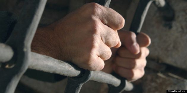 hands grabbing prison bars