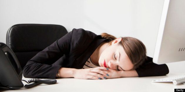 Studio shot of young woman working in office napping