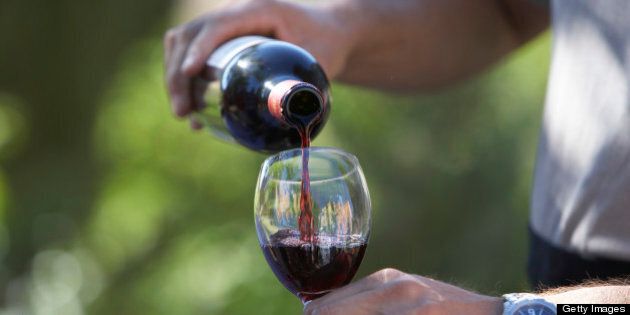 Man pouring wine, close-up of glass