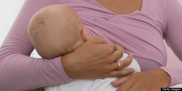Mother breastfeeding baby daughter (6-11 months)