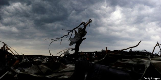 Rain clouds roil over a tornado devastated neighborhood on May 23, 2013 in Moore, Oklahoma. Severe thunderstorms barreled through this Oklahoma City suburb at dawn Thursday, complicating clean-up efforts three days after a powerful tornado killed 24 people and destroyed 2,400 homes. More rain was forecast to fall on Moore, soaking the disaster zone where residents had just the day before, under clear blue skies, started picking through the rubble of their destroyed houses to recover personal effects. AFP PHOTO/Jewel Samad (Photo credit should read JEWEL SAMAD/AFP/Getty Images)