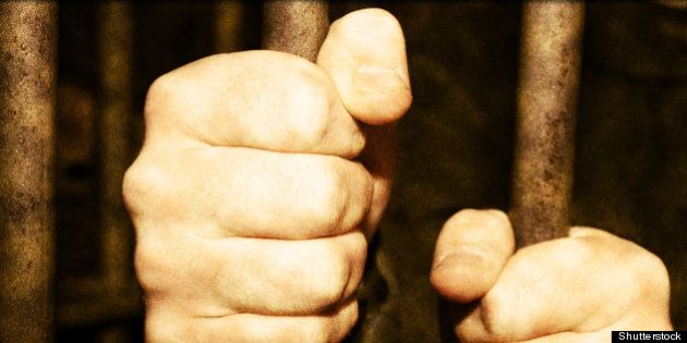hands of a man in jail