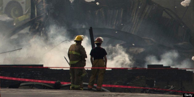 LAC-MEGANTIC QC - JULY 7: Firemen looked at the smouldering remains of a derailed train. Three people have now been declared dead and dozens remain missing after a train derailment caused a massive explosion in the quaint Quebec town of Lac-MÈgantic. (Lucas Oleniuk/Toronto Star via Getty Images)