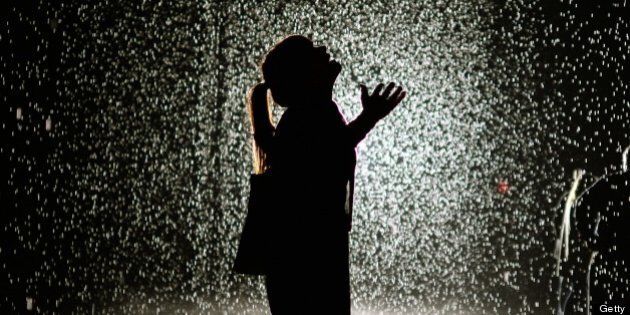 A visitor at the 'Rain Room' at MOMA ( The Museum of Modern Art ) May 20, 2013. MoMA PS1 is presenting as part of a major component of EXPO 1: New York, a exhibit entitled Rain Room (2012), which will be presented at The Museum of Modern Art, from May 12 through July 28, 2013. A large-scale environment by Random International, Rain Room is a field of falling water that pauses wherever a human body is detected?offering visitors the experience of controlling the rain. 'MANDATORY MENTION OF THE ARTIST UPON PUBLICATION' AFP PHOTO / TIMOTHY CLARY (Photo credit should read TIMOTHY CLARY/AFP/Getty Images)