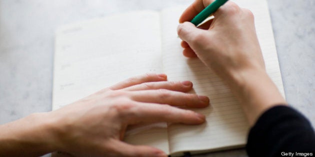 Woman writing on diary