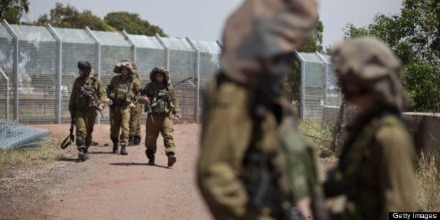 GOLAN HEIGHTS - MAY 07: (ISRAEL OUT) Israeli soldiers patrol next to the border fence May 7, 2013 on border with Syria, in the Israeli-annexed Golan Heights. Syria has accused Israel of launching a series of airstrikes on targets near the Lebanon/Syria border, including an arms shipment and the Jamraya research centre, that was thought to produce chemical weapons. (Photo by Uriel Sinai/Getty Images)