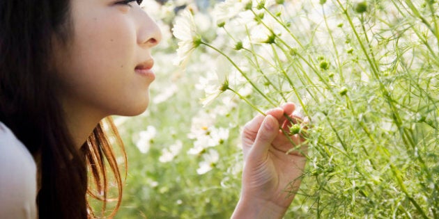 a woman smelling a flower