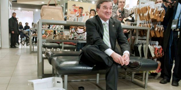 Canadian Finance Minister Jim Flaherty shows tries on new shoes as he shops in Ottawa on March 28, 2012 as part of the tradition of budget day. The tradition holds that Ministers of Finance purchase or wear new shoes when the budget is delivered. AFP PHOTO/ROGERIO BARBOSA (Photo credit should read ROGERIO BARBOSA/AFP/Getty Images)