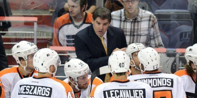 Philadelphia Flyers head coach Peter Laviolette speaks with his players in the third period of a preseason game against the Washington Capitals at the Verizon Center in Washington, D.C., Friday, September 27, 2013. The Capitals defeated the Flyers, 6-3. (Chuck Myers/MCT via Getty Images)
