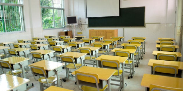 desk and chairs in classroom.