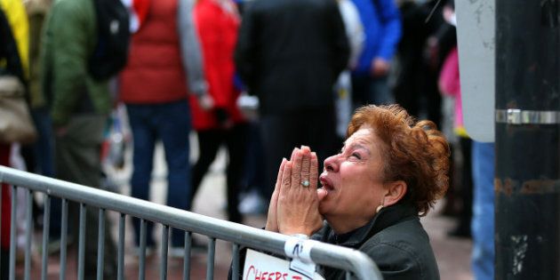 BOSTON - APRIL 15: A woman kneels and prays at the scene of the first explosion on Boylston Street near the finish line of the 117th Boston Marathon on April 15, 2013. (Photo by John Tlumacki/The Boston Globe via Getty Images)