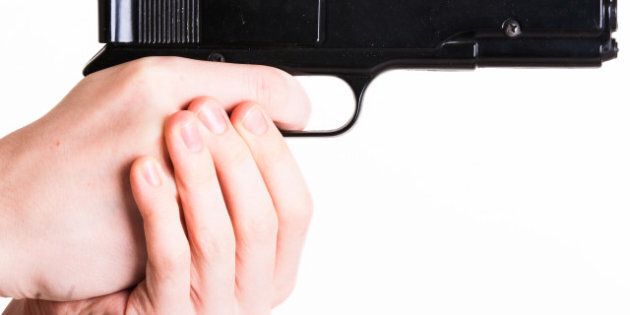teen holds a handgun on white...