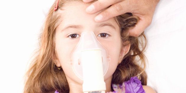 little girl inhaling medicine