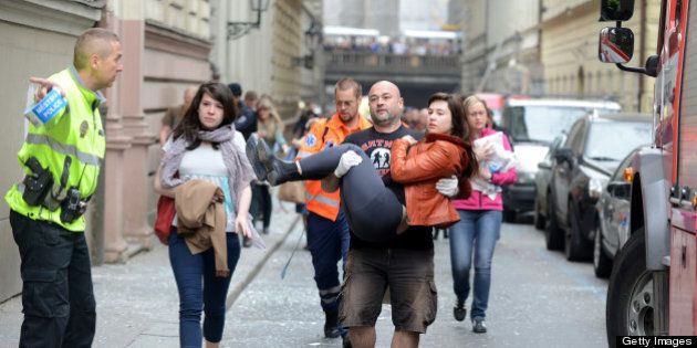 A man carries a young woman injured by a powerful gas blast in Prague's historic center on April 29, 2013. The blast injured up to 20 people, four seriously, rescuers said, adding that it was possible some people were buried in the rubble. AFP PHOTO / MICHAL CIZEK (Photo credit should read MICHAL CIZEK/AFP/Getty Images)