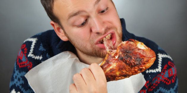 happy young man eating meat