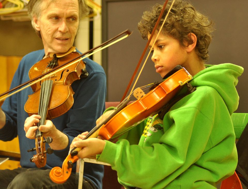 Un jeune apprend à jouer du violon