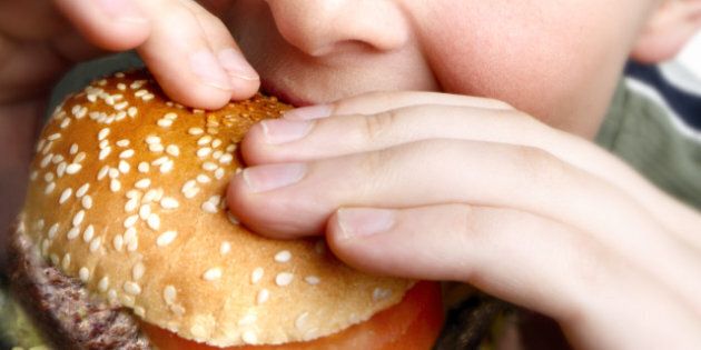 young boy eating cheeseburger