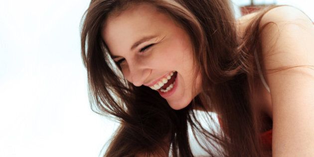 Happy woman laughing against white background