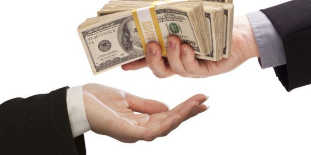 Handing Over Stacks of Cash to Other Hand Isolated on a White Background.