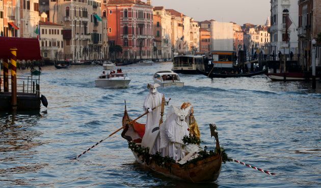 Des personnes masquées circulent en gondole à Venise pendant le célèbre Carnaval, une des périodes fortes du tourisme dans cette ville de renommée mondiale.