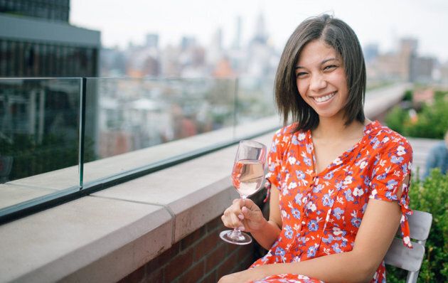 Jeune femme souriante boit du vin