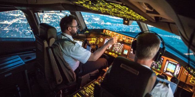 Two pilots at work during departure of Dallas Fort Worth Airport in United States of America. The view from the flight deck with high workload the beginning night through the wind shield