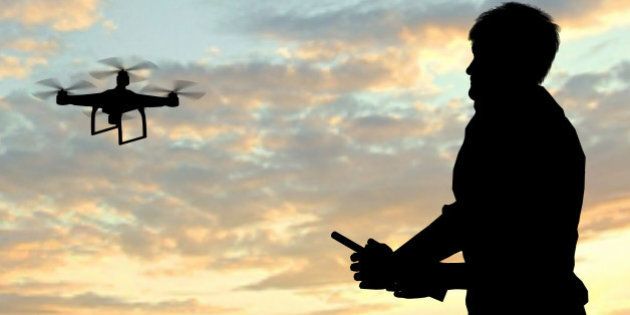 man operating of flying drone quadrocopter at sunset
