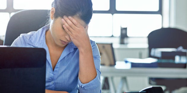 Shot of a businesswoman experiencing stress at work