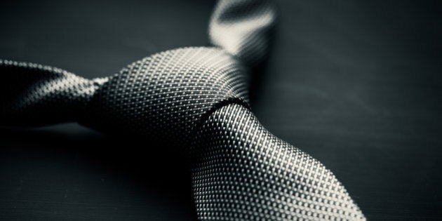 Soft focus photo of grey man's tie on dark background in the style of Fifty Shades of Grey.