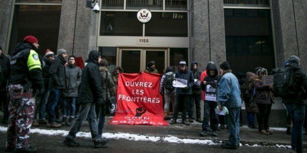 MONTREAL, CANADA - JANUARY 30 : Demonstrators hold a banner in front of the Consulate of the United States of America to protest US President Donald Trump, in Montreal on January 30, 2017. Demonstrators blocked the entrance to the U.S. Consulate protesting the recent ban on travel, transit and immigration by people hailing from seven predominantly Muslim countries, enacted through an executive order by U.S. President Donald Trump. (Photo by Amru Salahuddien/Anadolu Agency/Getty Images)