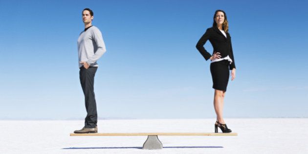 Businesswoman and businessman balanced on Seesaw. Gender equality concept.