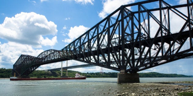 The Quebec Bridge is a combined road and rail bridge across the St. Lawrence River west of Quebec City. The Pierre Laporte Bridge (behind) is a road bridge over the St. Lawrence River, linking the cities of Quebec and Levis. It has the largest reach of all major Canadian suspension bridges.