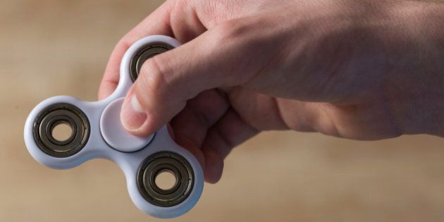 Young boy playing with fidget spinner toy to relieve stress at home