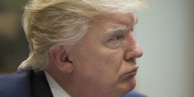 U.S. President Donald Trump listens during a meeting on health care in the Roosevelt Room of the White House in Washington, D.C., U.S., on Monday, March 13, 2017. Senate Democrats warned Republicans Monday that attempts to take funding away from Planned Parenthood or pay for Trump's border wall in a stopgap spending bill that must pass by late April would result in a government shutdown. Photographer: Michael Reynolds/Pool via Bloomberg