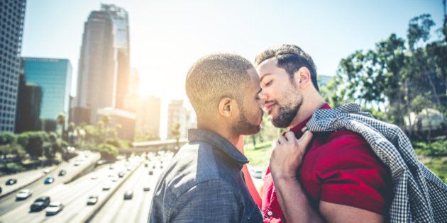 Homosexual couple at a romantic date outdoors - Multi-ethnic gay couple in love flirting and having fun