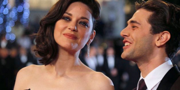 Director Xavier Dolan (R) and cast member Marion Cotillard pose on the red carpet as they arrive for the screening of the film