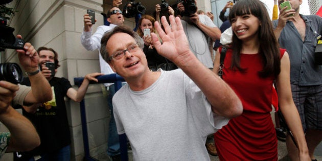 Marijuana advocate Marc Emery waves to his supporters as he walks with his wife Jodie following his release from an American prison for selling marijuana seeds in the U.S., in Windsor, Ontario August 12, 2014. REUTERS/Rebecca Cook (CANADA - Tags: DRUGS SOCIETY CRIME LAW)