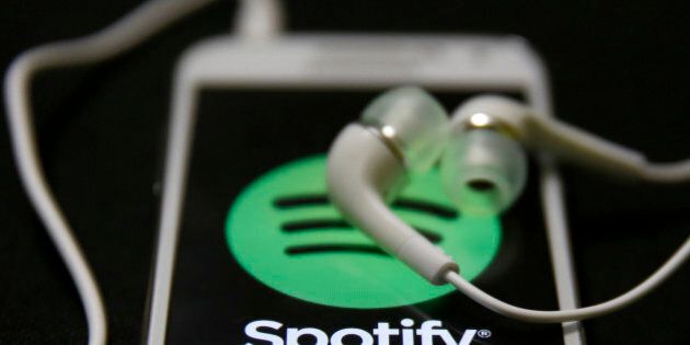 Earphones are seen on top of a smart phone with a Spotify logo on it, in Zenica February 20, 2014. Online music streaming service Spotify is recruiting a U.S. financial reporting specialist, adding to speculation that the Swedish start-up is preparing for a share listing, which one banker said could value the firm at as much as $8 billion (4 billion pounds). REUTERS/Dado Ruvic (BOSNIA AND HERZEGOVINA - Tags: SCIENCE TECHNOLOGY BUSINESS SOCIETY)