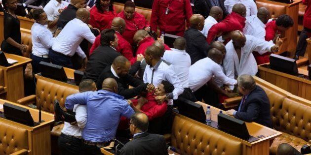 Economic Freedom Fighters (EFF, in red) party members of parliament are physically removed from the South African parliament after repeatedly ignoring the instructions of the Speaker, on May 17, 2016, in Cape Town.A brutal fistfight broke out in the South African parliament on May 17 as security guards ejected opposition lawmakers in an ugly fracas that underlined heightened political tensions over Jacob Zuma's presidency. / AFP / RODGER BOSCH (Photo credit should read RODGER BOSCH/AFP/Getty Images)
