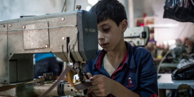 GAZIANTEP, TURKEY - MAY 16: A young Syrian refugee boy makes shoe parts in a Turkish owned factory on May 16, 2016 in Gaziantep, Turkey. Since fleeing the war and after the new E.U - Turkey deal effectively shutting down routes to Europe for many Syrian refugees, living in Turkey has become their only option, however there is very little stable work and little hope of building a future. Turkey's massive and largely unregulated garment industry is an attractive option for Syrians to work both legally and illegally despite low wages, long hours and poor conditions. It is a popular choice for Syrians living outside of the official refugee camps, who are offered no assistance from the state. Child labour amongst Syrian refugees is also a major concern, with children between the ages of 7-10yrs often working in clothing and shoe factories on shifts longer than 10 hours, earning them approximately 400TL per month (135USD) well below the Turkish minimum wage of 1,647TL a month (554USD). For many children working in garment factories is their only choice as many have lost their father's, uncles, and brothers to the war and now find themselves as the head of the family, forced to earn money to provide for their families basic needs. Turkey's garment industry is a massive supplier to both Europe and the Middle East, as part of the E.U -Turkey deal it was announced that Syrians who had been in the country for more than six months would be able to apply for a work permit allowing them to receive the minimum wage and some work benefits, which would aim at protecting workers from discrimination. (Photo by Chris McGrath/Getty Images)