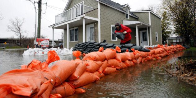 A man places sandbags outside a home in a flooded residential area in Gatineau, Quebec, Canada, May 7, 2017. REUTERS/Chris Wattie