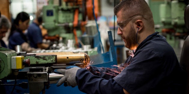 Latin American man working at a factory cutting metal