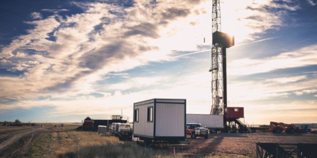 Beautiful sky above a drilling Fracking Rig in the vast wild west of AmericaFracking Oil Well is conducting a fracking procedure to release trapped crude oil and natural gas to be refined and used as energy