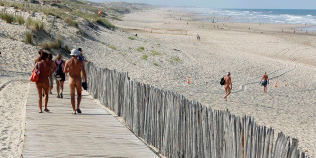 Holiday makers walk on the boardwalk as they make their way to the beach at the Centre Helio-Marin (Center for Sun and Sea) naturist campsite on the Atlantic coast in Montalivet, southwestern France, August 2, 2013. The Centre, created in July 1950, was the first vacation nudist camp to open in Europe. France is host to some 83 naturist sites where 60% of the holiday makers are foreigners. During the peak summer holiday period, 14,000 people spend their vacation at this nudist campsite on the Atlantic Ocean. Picture taken August 2, 2013 REUTERS/Regis Duvignau (FRANCE - Tags: TRAVEL SOCIETY) TEMPLATE OUT