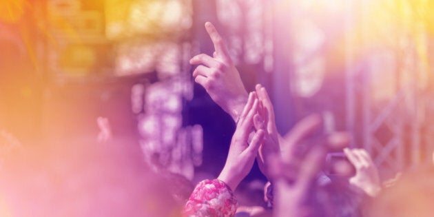 Fans Applauding To Music Band for Live Performing a Concert on Stage in Open Arena, Selective Focus Toned Image with Sunflares.