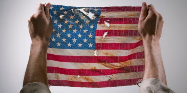 Hands holding torn America flag